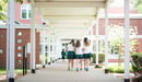 Three middle school students at The Ellis School walk together outside between classes.
